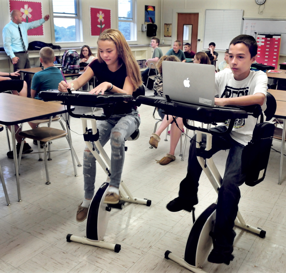 China Middle School eighth-graders Morgan Presby and Colby Marston study and pedal at the two bike desks as math teacher Josh Lambert leads the class Wednesday.