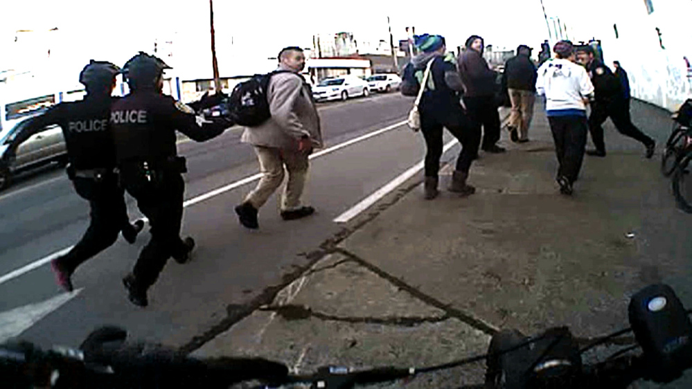  In this image from a Seattle police body camera video, officers move in to make an arrest during a Black Lives Matter demonstration in January. 
The Associated Press