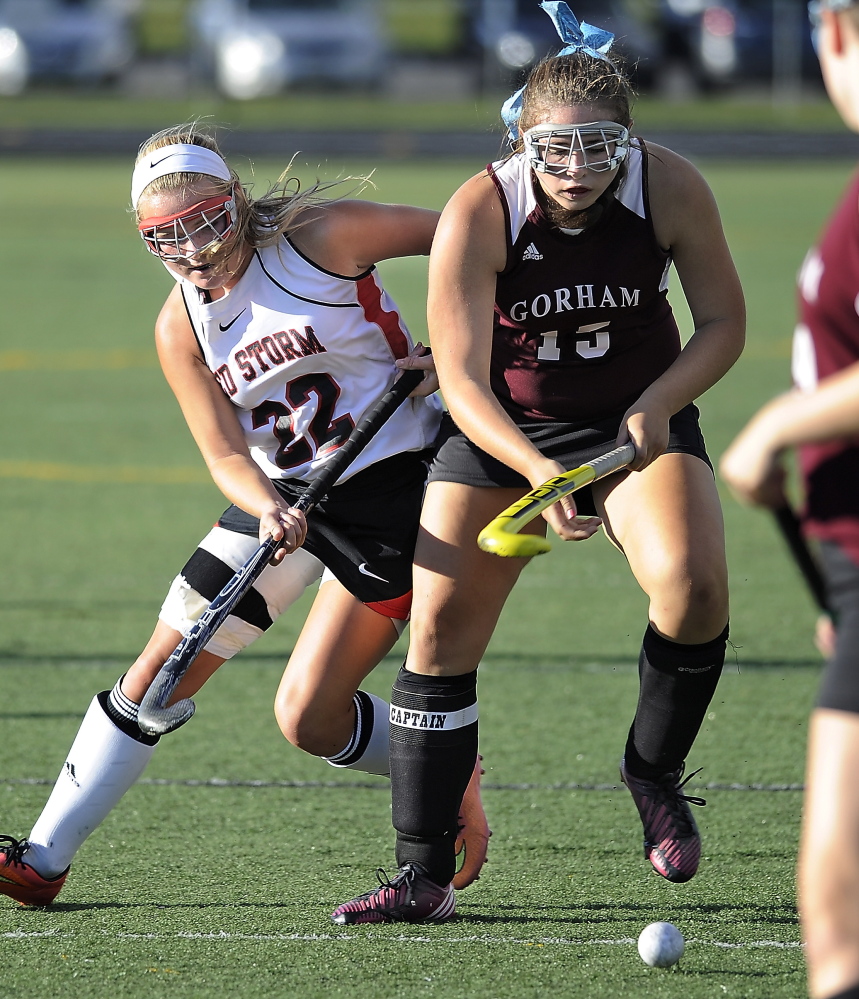 Emmy Viernes of Gorham attempts to control the field hockey ball and hold off  Kristen Levesque of Scarborough. Scarborough improved its record to 4-0 and dropped Gorham to 0-4.