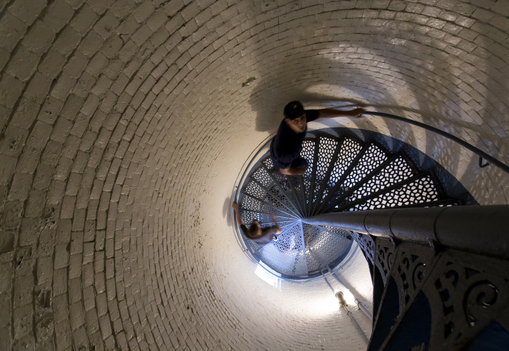 U.S. Coast Guard fireman Justin Busch leads a tour group up the spiral staircase within Portland Head Light.