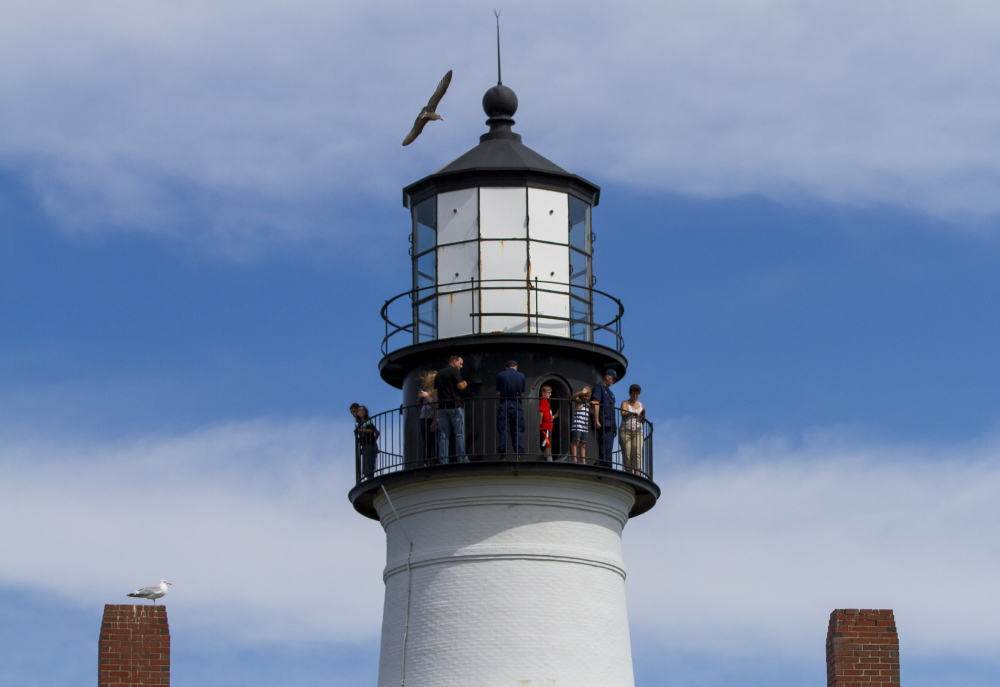 Visitors take in the view from the top of Portland Head Light.