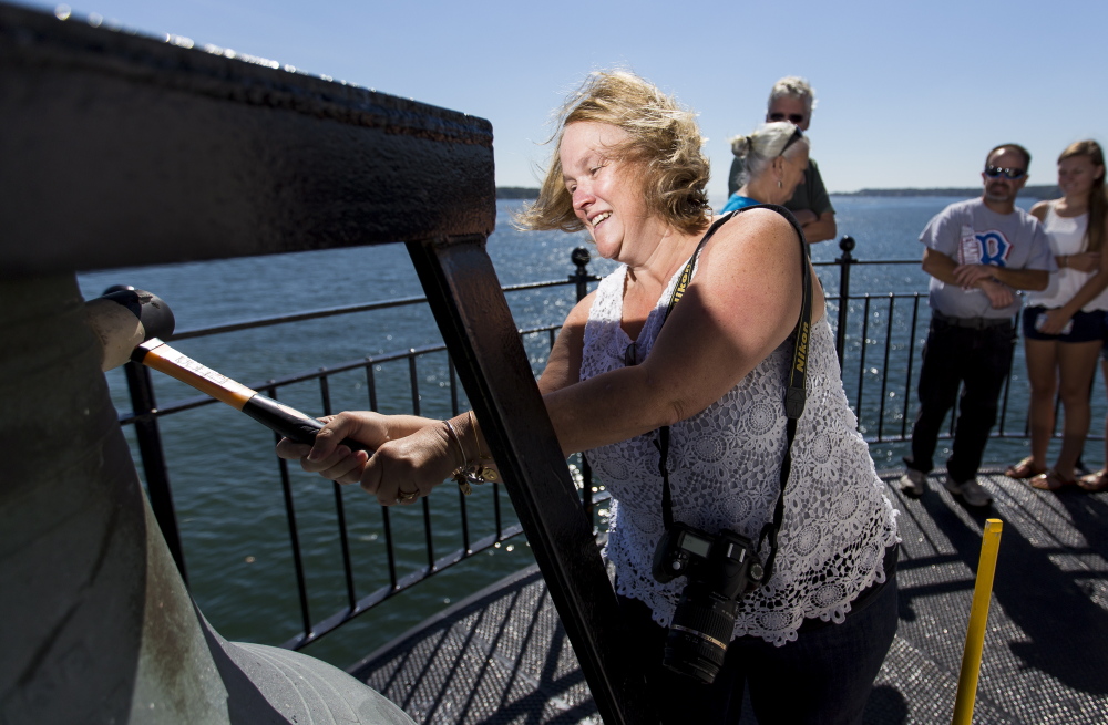 Holly Conroy, of Leominister, Mass., rings the bell at Spring Point Light during Maine Open Lighthouse Day on Saturday. Twenty-three lighthouses, including Bug Light and Portland Head Light were opened to visitors.