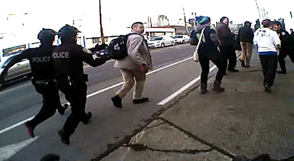 In this image from video from a Seattle police body camera video, police move in to make an arrest during a Black Lives Matter demonstration in January.