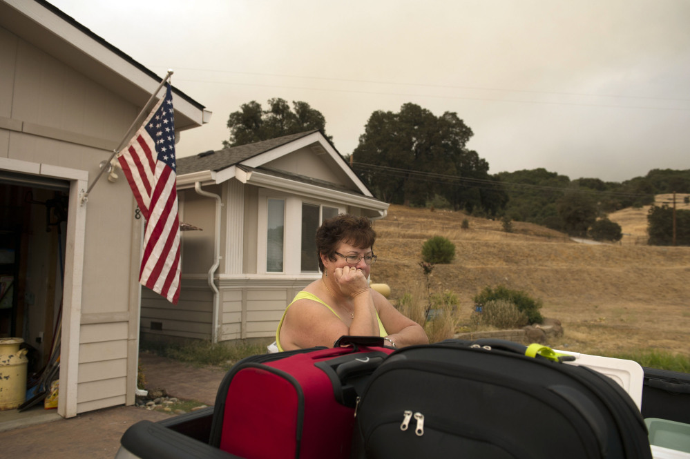Ready to evacuate, Teri Goodall waits outside her home in San Andreas as the Butte Fire burns out of control north of San Andreas, Calif., on Friday. Jose Luis Villegas/The Sacramento Bee via AP