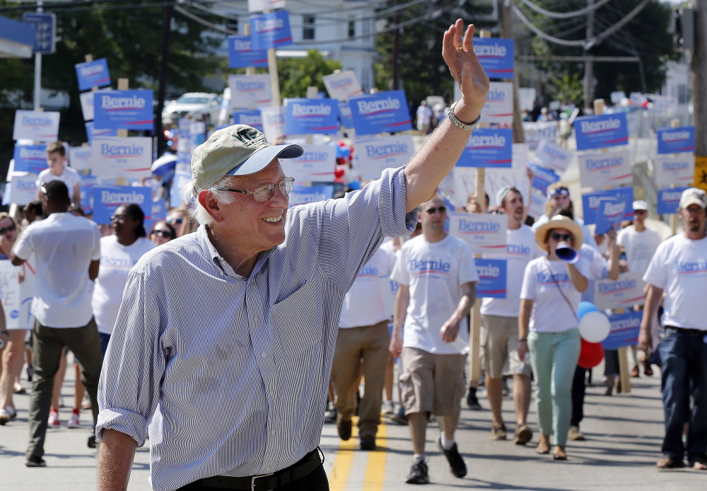 Democratic presidential candidate Sen. Bernie Sanders, I-Vt., marches with supporters in the Labor Day parade Monday in Milford, N.H. He is rapidly growing his campaign.