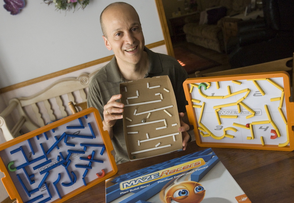 Game inventor Andy Geremia holds a prototype of his Maze Racers game, which he first constructed from a cereal box and straws at his home in Southington, Conn. After winning first place and $5,000 at a competition in 2014, he signed a licensing agreement with FoxMind Toys & Games. The game is now available on Amazon and through Barnes & Noble.