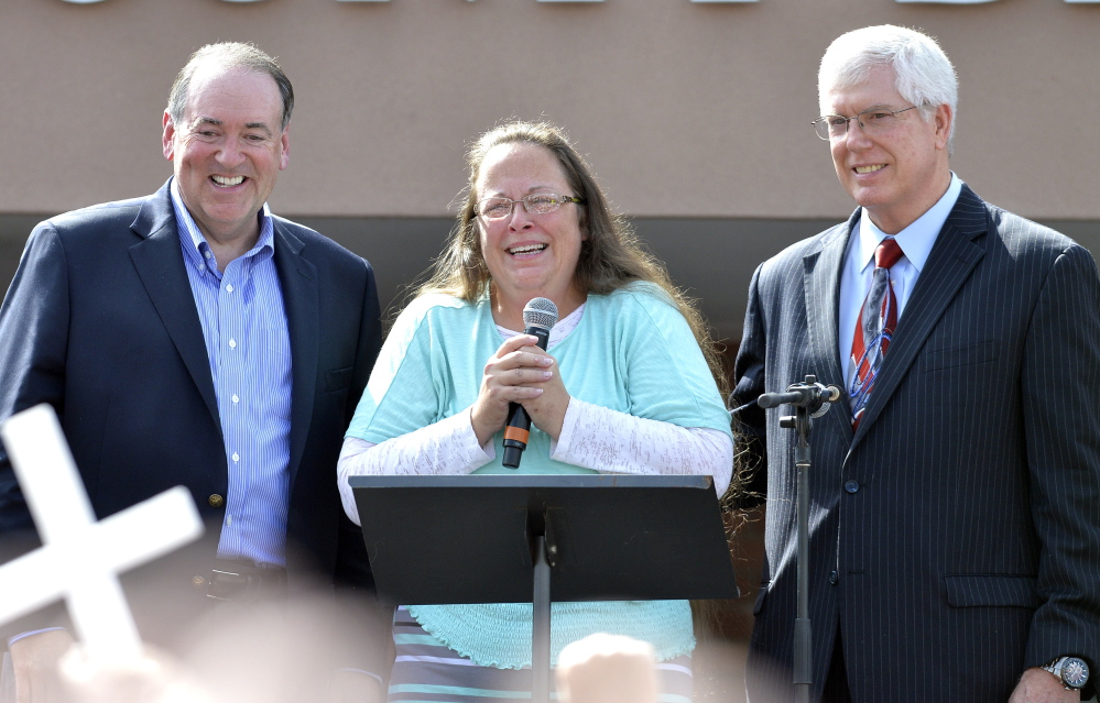 Kim Davis, with Republican presidential candidate Mike Huckabee, left, and attorney Mat Staver, founder of the Liberty Counsel, the Christian law firm representing Davis, greets the crowd after being released from jail Tuesday.
