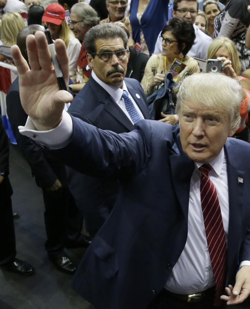 Republican Donald Trump waves to supporters after he bashed illegal immigrants, the media and Republican operatives at a Dallas rally.
