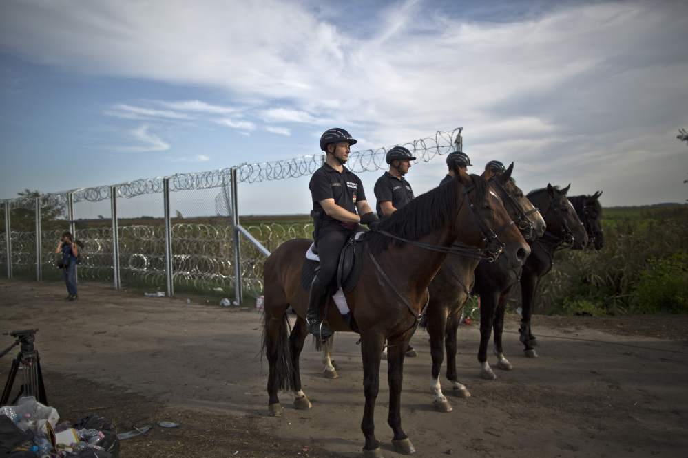 Hungarian police patrol near the fence after the border between Serbia and Hungary was closed, in Roszke, Hungary, on Monday.