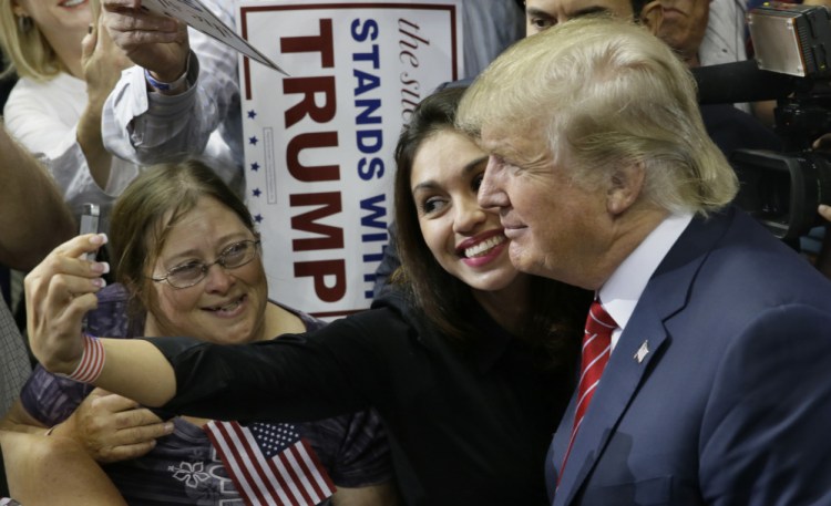 The Associated Press Republican presidential candidate Donald Trump takes a photo with a supporter after speaking at a campaign event in Dallas, Monday. The Republican front-runner is expected to address foreign policy during an appearance aboard the USS Iowa.