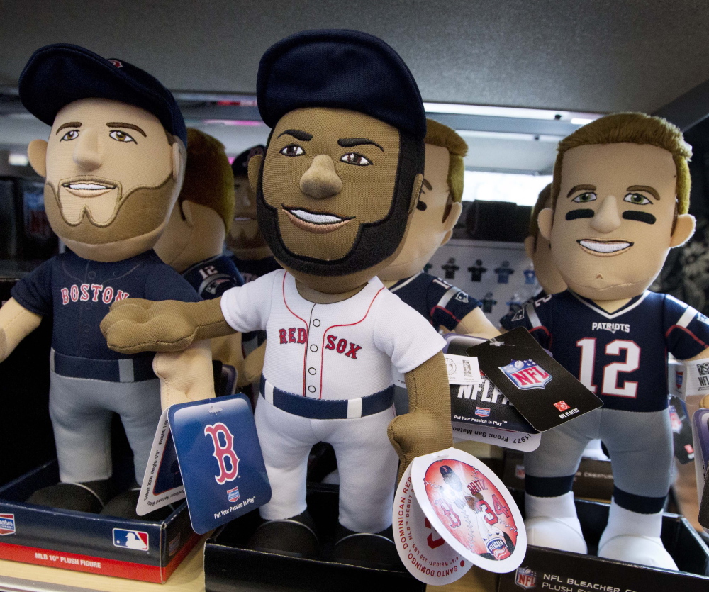 Dolls depict New England Patriots quarterback Tom Brady, right, and Boston Red Sox players David Ortiz, center, and Dustin Pedroia at the CityTarget store in Boston.