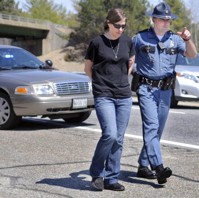 Demitria Buhalis is escorted by Maine State Police Sgt. Patrick Hood to a cruiser while being arrested on Interstate 95 in West Gardiner on April 22. Buhalis pleaded guilty Tuesday to criminal threatening with a dangerous weapon in connection with a road rage incident that day on Interstate 95 in Sidney.