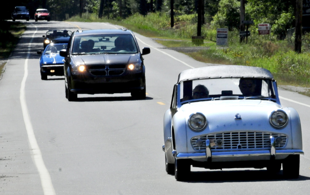 Allan McClure of Winslow drives his 1960 Triumph TR3A as other participants of a British car touring group follow – interrupted by a very non-British Chrysler van – on Route 8 in North Belgrade on Tuesday.