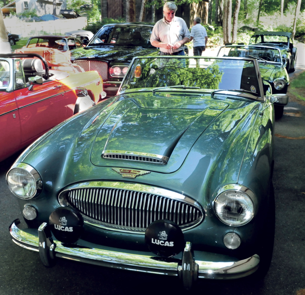 Ray Morrow of Smithfield admires an Austin Healey 3000 on Tuesday at the home of Steve and Janet Towle in North Belgrade. The car was one of a caravan of British-made cars on their way from Nova Scotia to Stowe, Vermont, for the British Invasion car show.