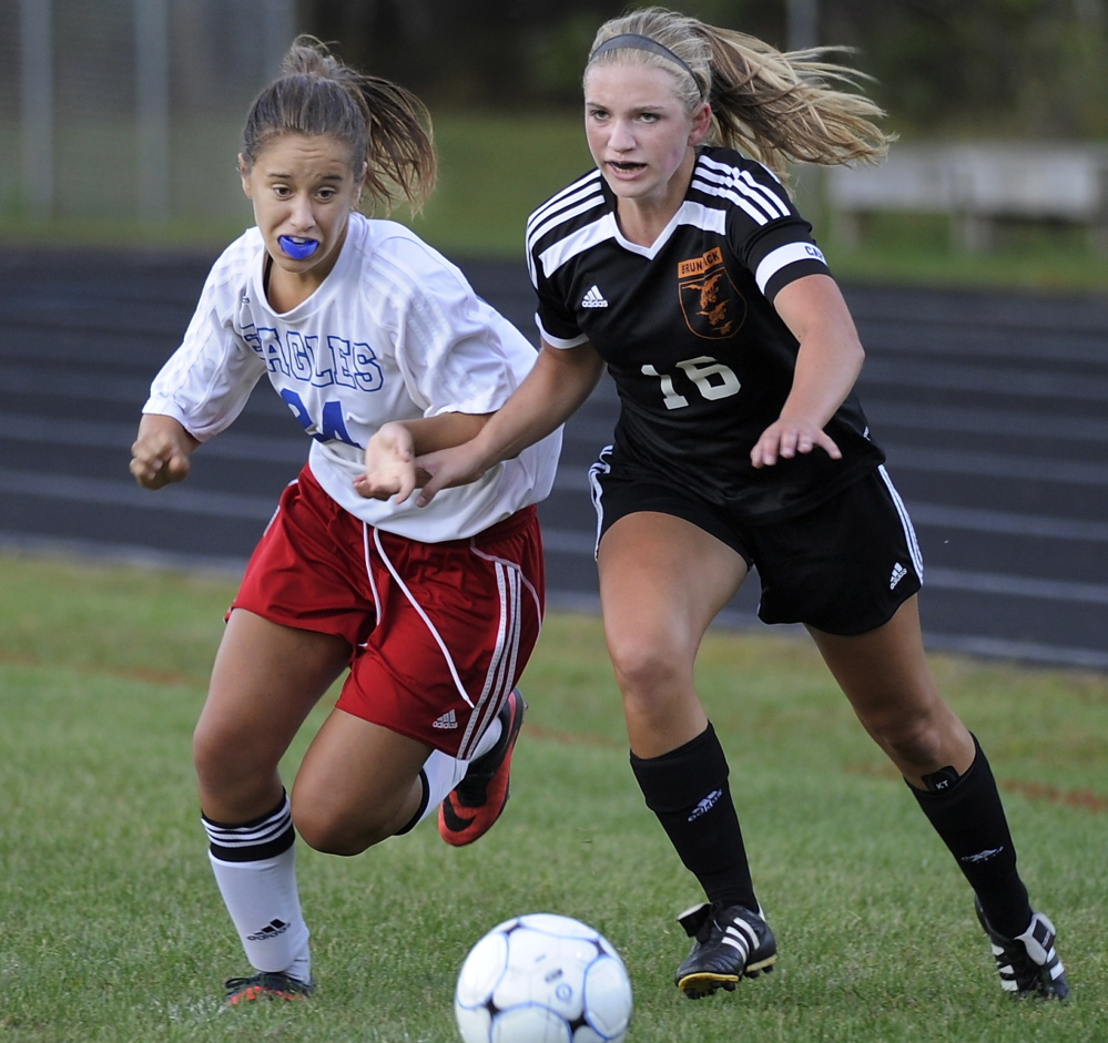 Chloe Beattie of Mt. Ararat, left, and Molly Gramins of Brunswick chase a loose ball Tuesday night during Brunswick’s come-from-behind 3-2 victory in a Class A North schoolgirl soccer game at Topsham.