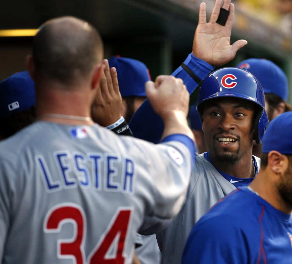 Austin Jackson, second from right, celebrates with Jon Lester in the second game of Tuesday’s doubleheader. The Cubs and Pirates split.