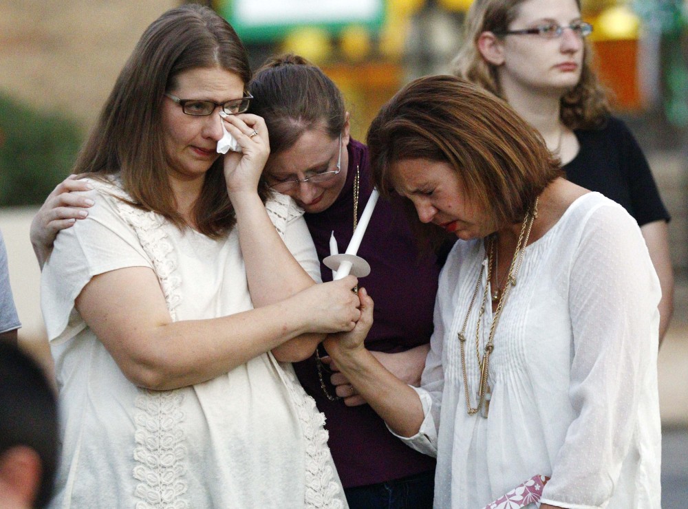 Liz Schmidt, left, widow of Delta State University history professor Ethan Schmidt, who was murdered by a colleague in his office Monday, is comforted by friends Jenn Westmoreland, center, and Amy Cotrell prior to a candlelight memorial in his honor on the Cleveland, Miss., campus, Tuesday.