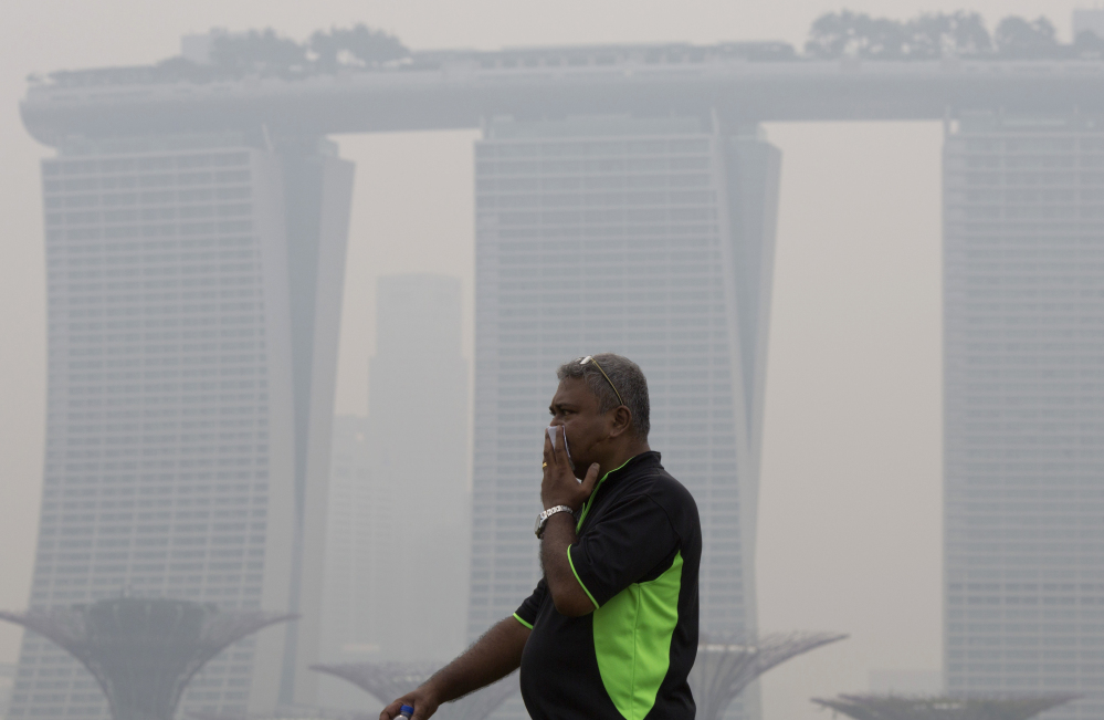 A man covers his nose during a hazy day in Singapore. Air pollution is killing 3.3 million people a year worldwide, says a study that includes this surprise: Farming plays a large role in smog and soot deaths in industrial nations.