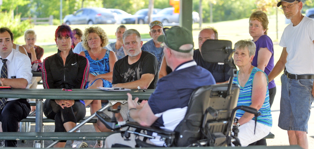 Audience members listen as Augusta police Chief Robert Gregoire answers a question from an audience member Thursday during a public meeting in the Mill Park gazebo in Augusta.