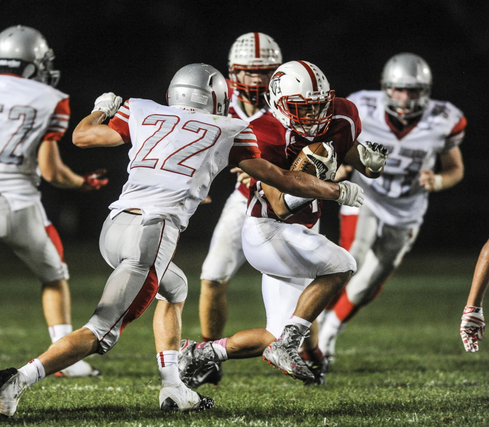 SANFORD, ME - SEPTEMBER 18: Sanford running back Zach Kang attempts to make it past the line of scrimmage while South Portland defensive back Spencer Houlette goes to tackle at Sanford High School in Sanford, ME on Friday, September 18, 2015. (Photo by Whitney Hayward/Staff Photographer)