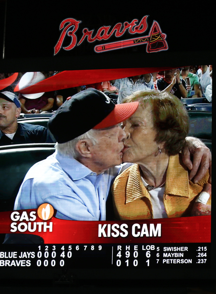 Former President Jimmy Carter kisses his wife, Rosalynn, on the “Kiss Cam” at an Atlanta Braves baseball game this week.