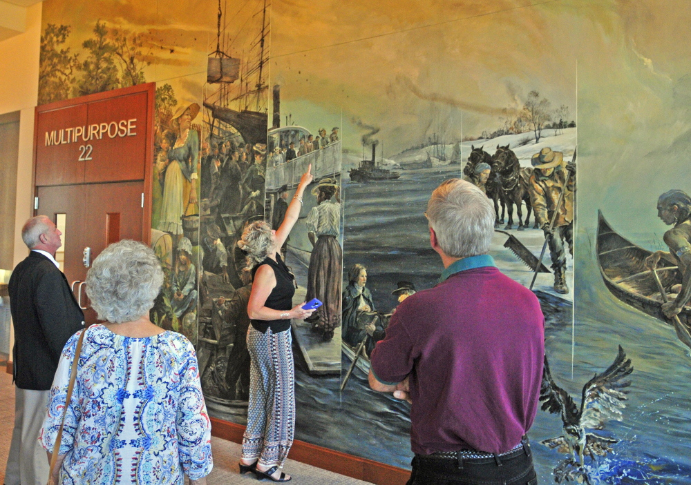 Lisa Gilbert points out an image of Maine Supreme Judicial Court Chief Justice Leigh Saufley standing at a ship railing in the large mural painted by Christopher Cart before the ceremonial opening Friday at the new Capital Judicial Center in Augusta. Cart, of Hallowell, said all the faces are based on real people, including some who helped build or now work in the building.
