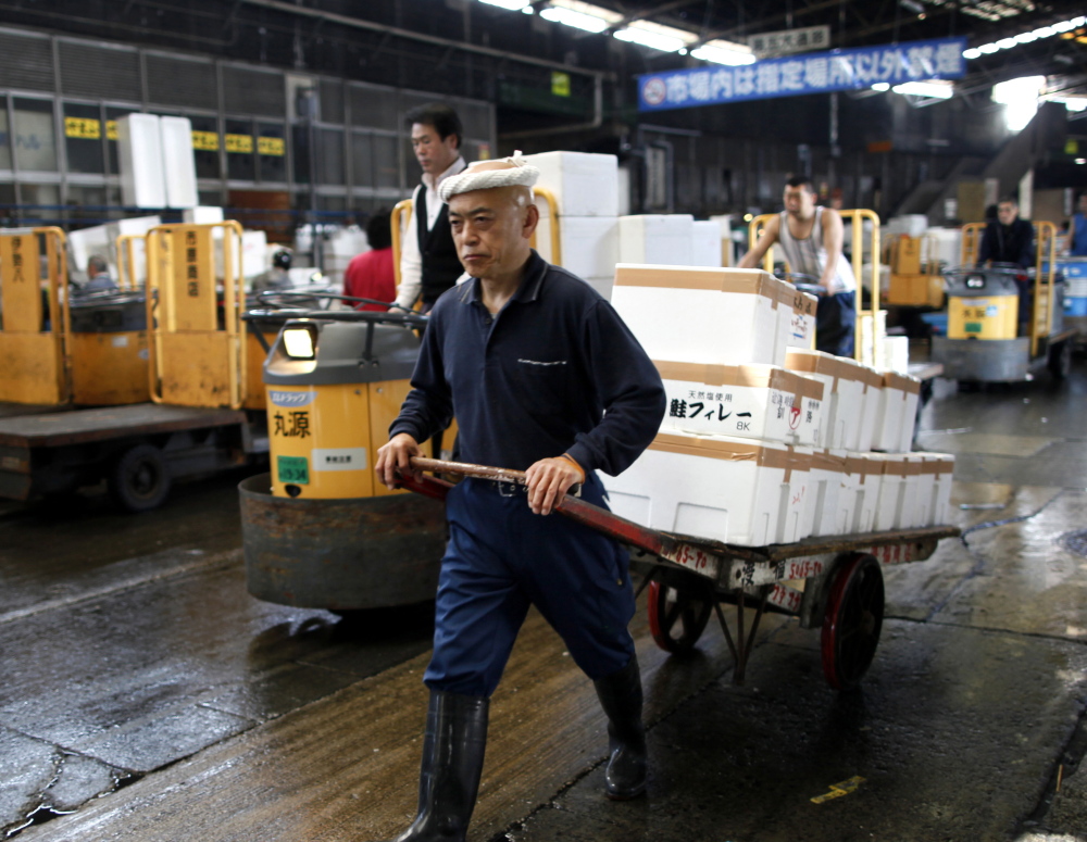 A fish dealer pulls a cart carrying marine products in containers made of styrofoam after the day’s auction at Tsukiji Wholesale Market in Tokyo.