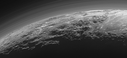 New Horizons photo released Thursday by NASA shows the atmosphere and surface features of Pluto backlit by the sun.