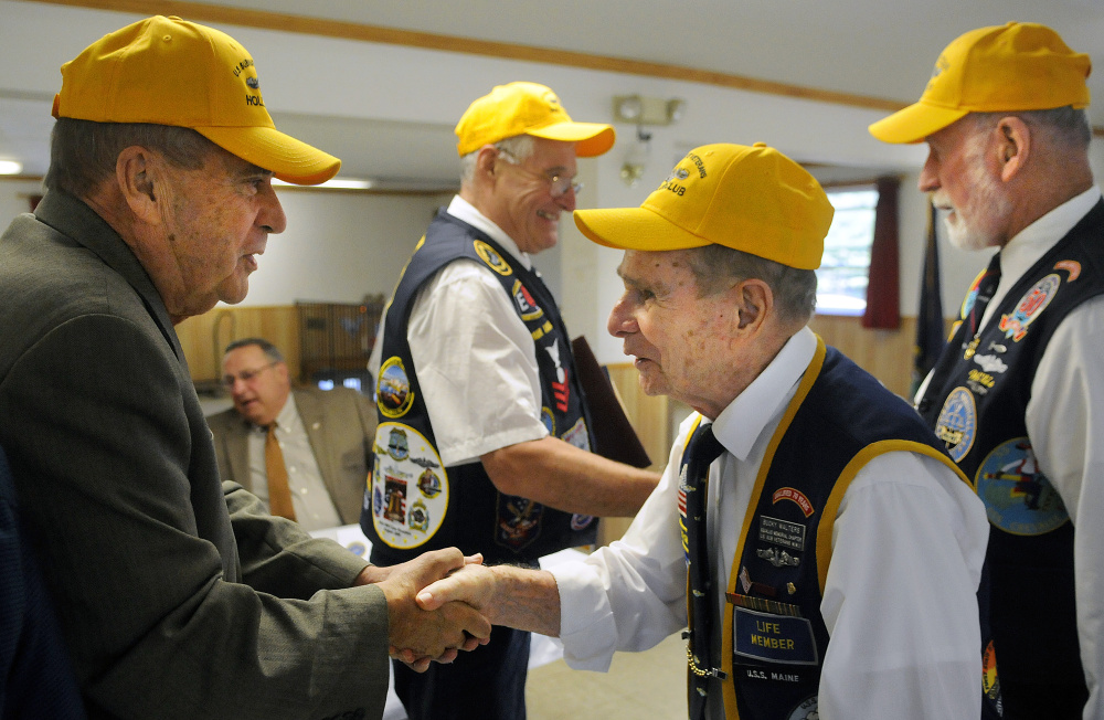 John Morris, left, of West Gardiner is congratulated Sunday by Bucky Walters as Willis Clifford, right, congratulates Paul Talbot of Corinna for induction into the Holland Club, an organization for those who have lived at least 50 years after they first qualified on submarines.