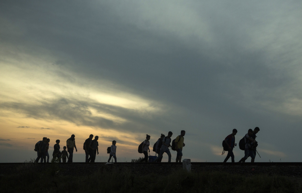 Migrants walk along the railway tracks near the town of Roszke, Hungary. Among the tens of thousands fleeing war and despair in the Middle East are many who have escaped areas ruled by Islamic State extremists who deliver harsh punishments to those who break strict rules.