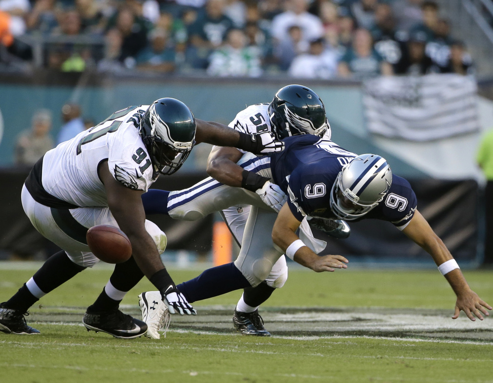 Cowboys quarterback Tony Romo fumbles while being sacked by Jordan Hicks of the Eagles during Dallas’ 20-10 win Sunday. Romo suffered a broken collarbone.