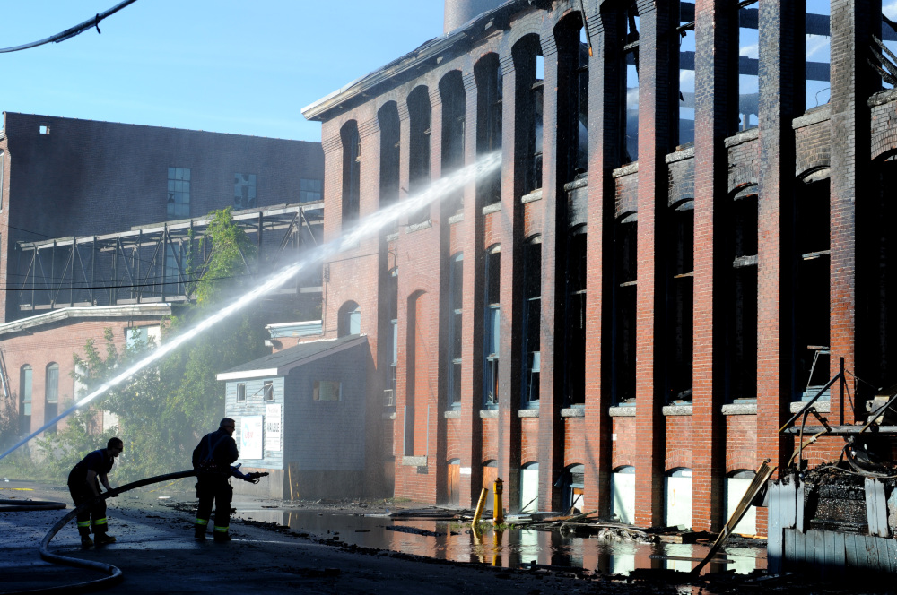 Firefighters were still hosing down hot spots and pumping water onto the former Hudson Manufacturing building in Haverhill, Mass., on Monday. The building caught fire around 5 p.m. Sunday and smoke was visible 20 miles away.