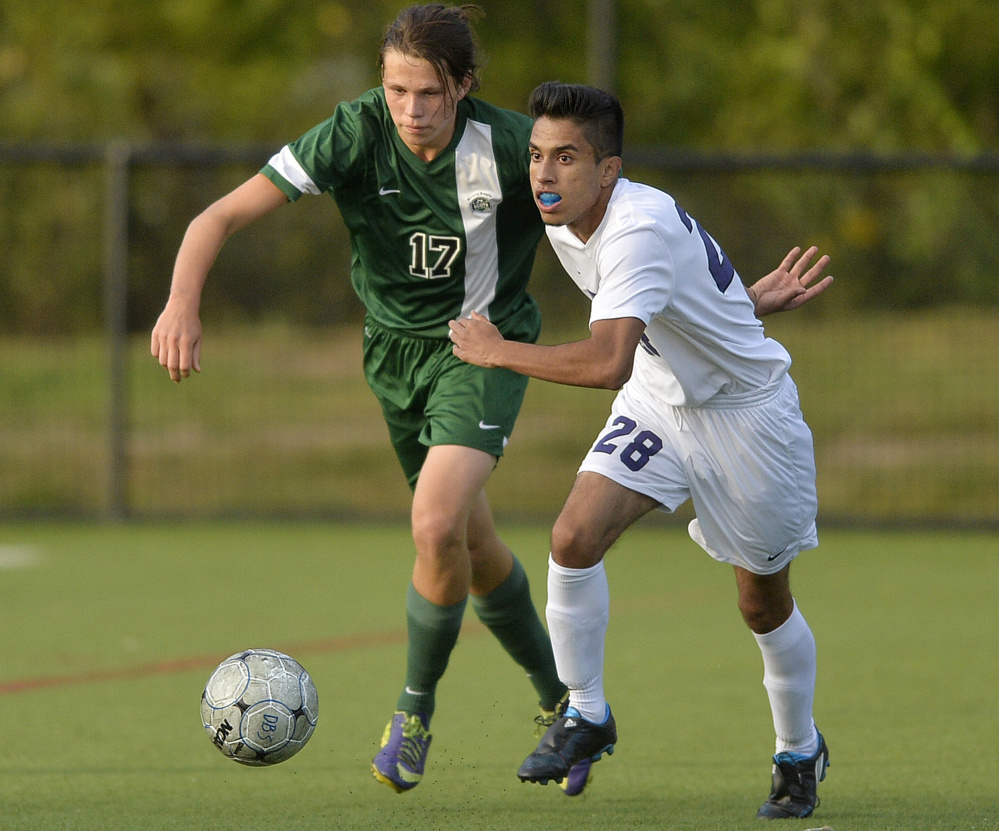 Bonny Eagle’s Aaron Rae, left, and Deering’s Muzamell Osmani Azizi race for the ball during the Rams’ 5-3 boys’ soccer win Monday.