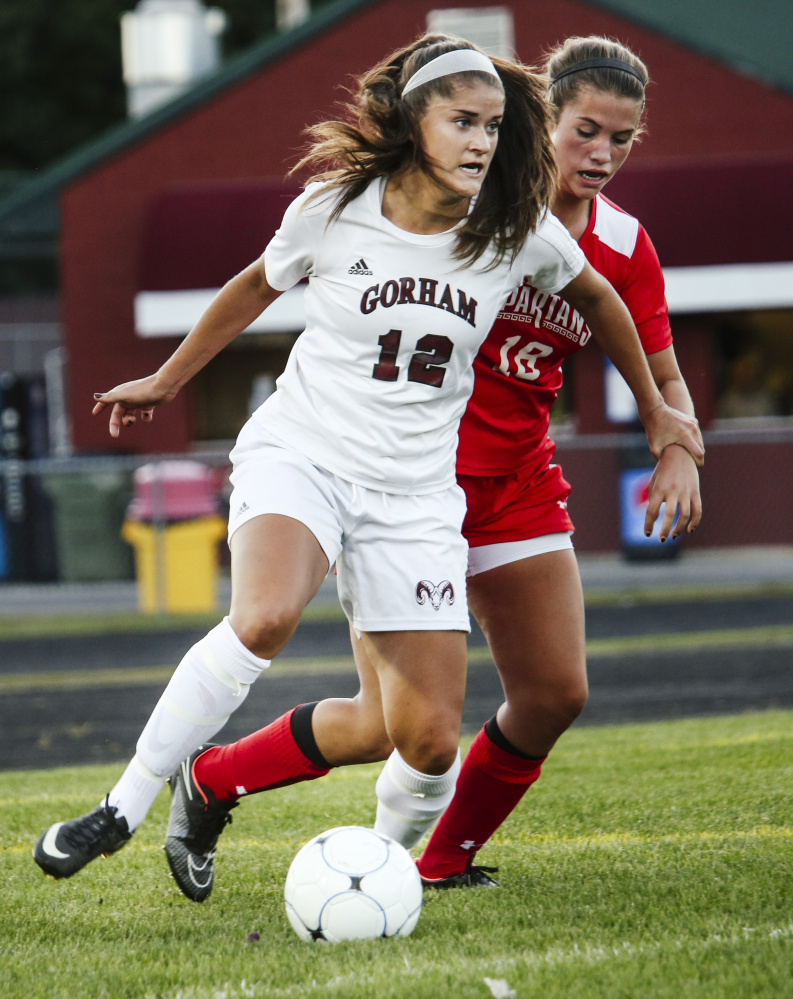 Elizabeth Sullivan of Gorham looks for an open teammate Wednesday night while being pursued by Emma Graves of Sanford during Gorham’s 3-0 victory.