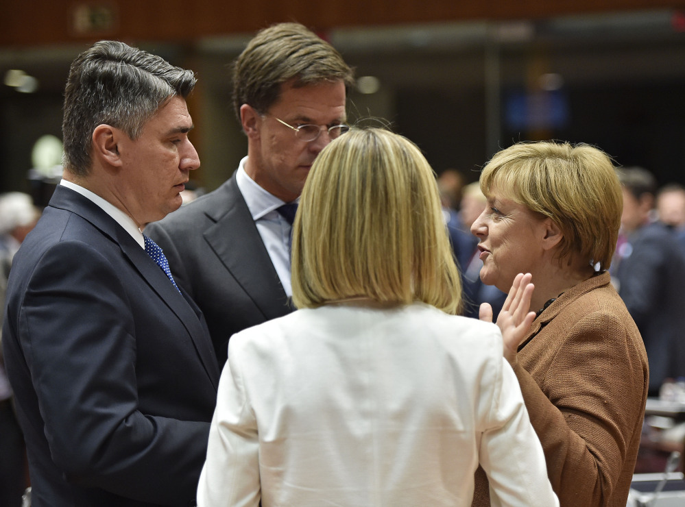 Croatian Prime Minister Zoran Milanovic  and Dutch Prime Minister Mark Rutte listen to German Chancellor Angela Merkel, from left,  as they arrive for an emergency EU heads of state summit on the migrant crisis at the EU Commission headquarters in Brussels on Wednesday, Sept. 23, 2015.  (AP Photo/Martin Meissner)