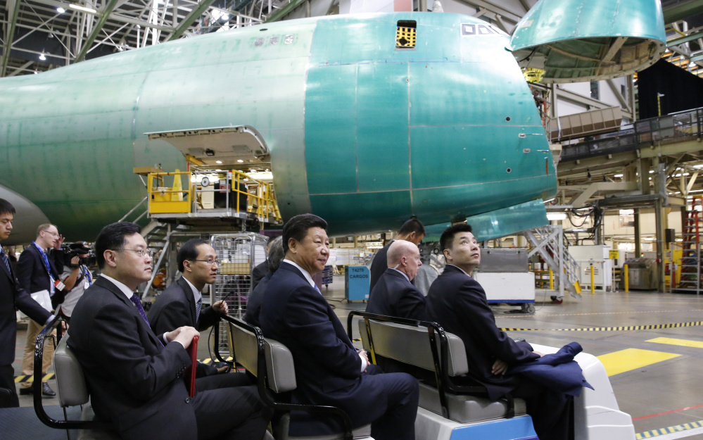 Chinese President Xi Jinping, center, tours the Boeing assembly line Wednesday in Everett, Wash. Boeing said that Chinese companies have agreed to buy 300 jets and build an aircraft assembly plant in China.