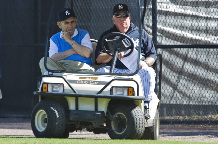 Hall of Famer Yogi Berra, left, and Maine native Stump Merrill watch a workout in 2011 at the Yankees’ spring training camp in Tampa, Florida. Merrill was a special instructor at the camp, and one of his other duties in recent years was to escort Berra, who was approaching 90.