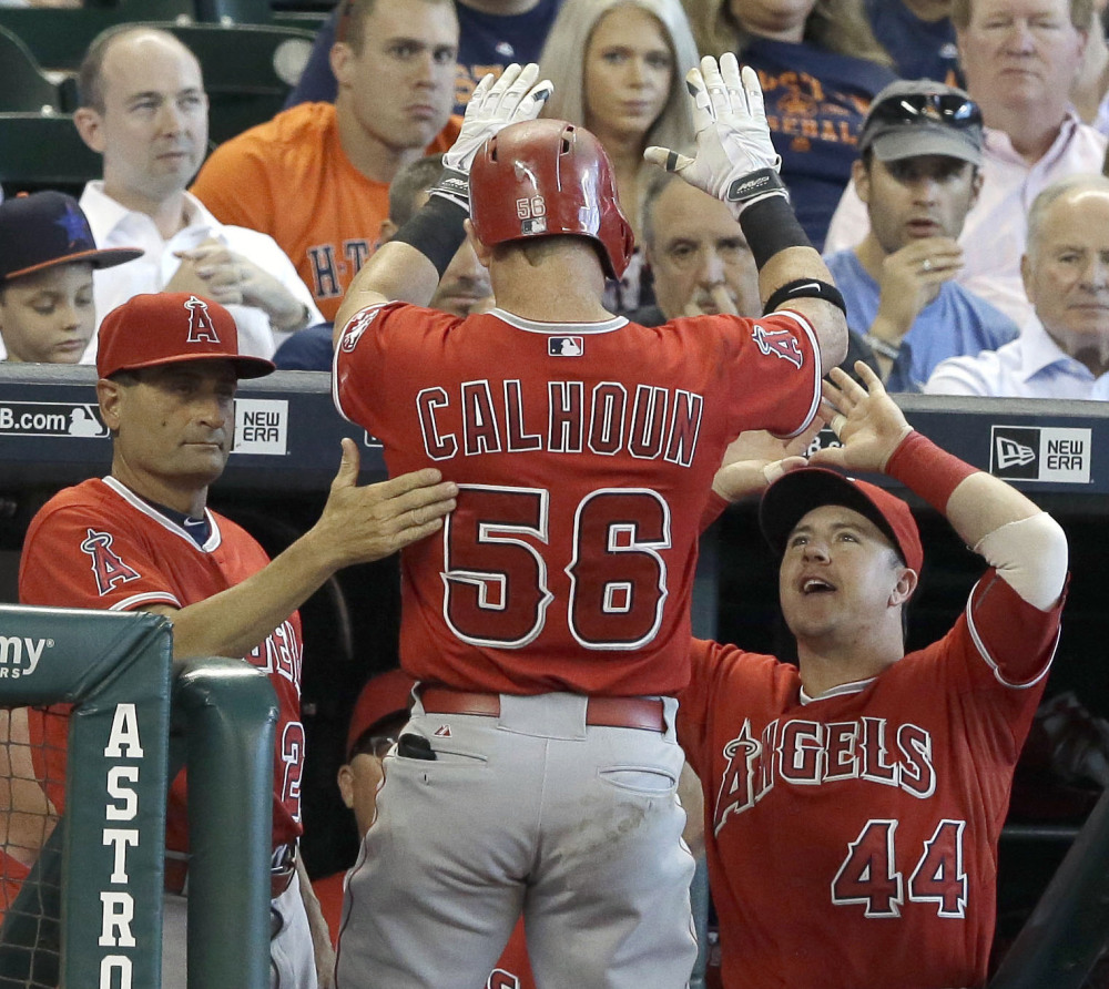 Kole Calhoun of the Angels is welcomed back to the dugout after hitting a solo homer in a 6-5 Los Angeles win over the Astros at Houston on Wednesday.