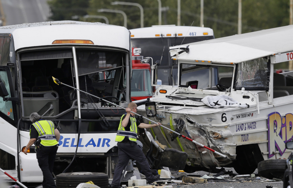 Officials work at the scene of a crash involving a “Ride the Ducks” amphibious vehicle and a charter bus. Dozens  were seriously injured in the collision Thursday.