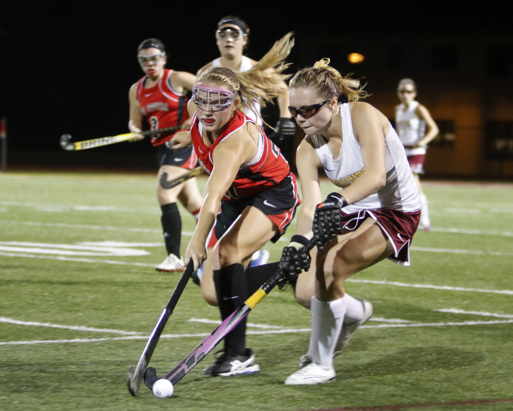 Scarborough’s Ashley Levesque, left, and Thornton Academy’s Ali Ouellette battle for the ball in the second half in Thursday night’s field hockey game in Saco. Scarborough won 2-1.