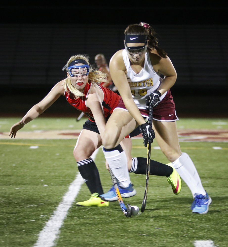 Scarborough’s Lucy Malia, left, puts defensive pressure on Thornton Academy’s Emma Dutremble in the second half of their field hockey game Thursday night at Saco. Scarborough won 2-1 to improve to 7-1.