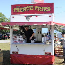 John Frake mans the Steve’s French Fries booth at the Oxford County Fair earlier this month. Nearly 900,000 people are expected to visit Maine’s agricultural fairs in 2015, according to the Maine Department of Agriculture, Conservation and Forestry. More than $1.5 million in premiums went to exhibitors this year. The season ends next month with the Fryeburg Fair, which runs Oct. 4-11. Gordon Chibroski/Staff Photographer