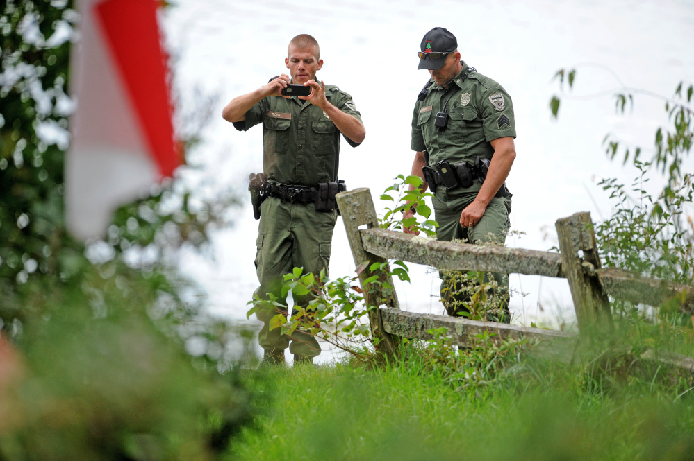 Maine wardens document the scene on Lovejoy Pond in Albion on Friday, where a man apparently drowned while fishing from a canoe with his father.