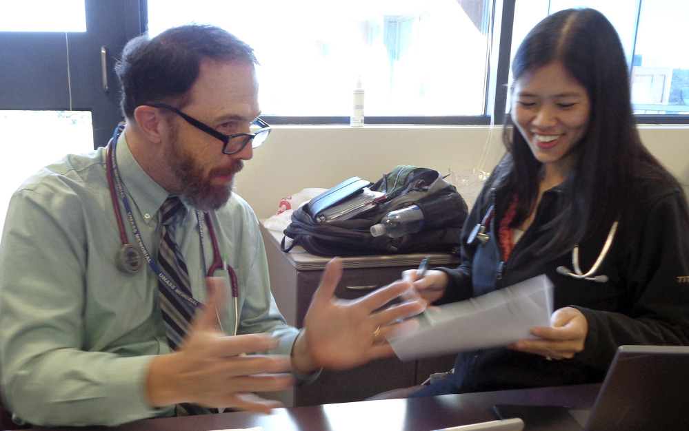 Dr. Rick Sacra reviews patient cases with Dr. Anna Chon at the Family Health Center in Worcester, Mass., where he advises doctors in training. Sacra contracted the deadly Ebola virus while delivering babies in a missionary-run hospital in Liberia a year ago.