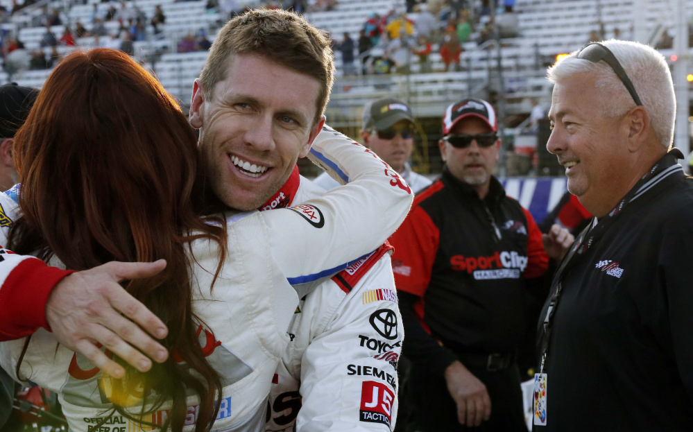 Carl Edwards gets a hug Friday after winning the pole position for Sunday’s NASCAR Sprint Cup at New Hampshire Motor Speedway in Loudon, N.H. Edwards also won the pole for the Sprint Cup racing in New Hampshire in July.