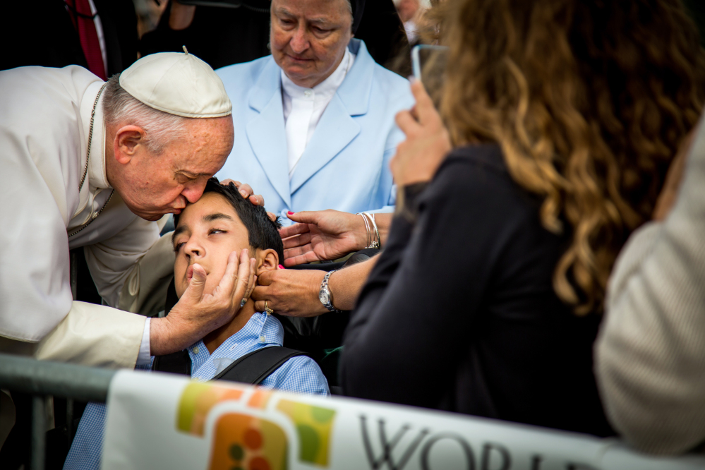 Pope Francis kisses and blesses Michael Keating, 10, of Elverson, Pa., after arriving in Philadelphia Saturday.