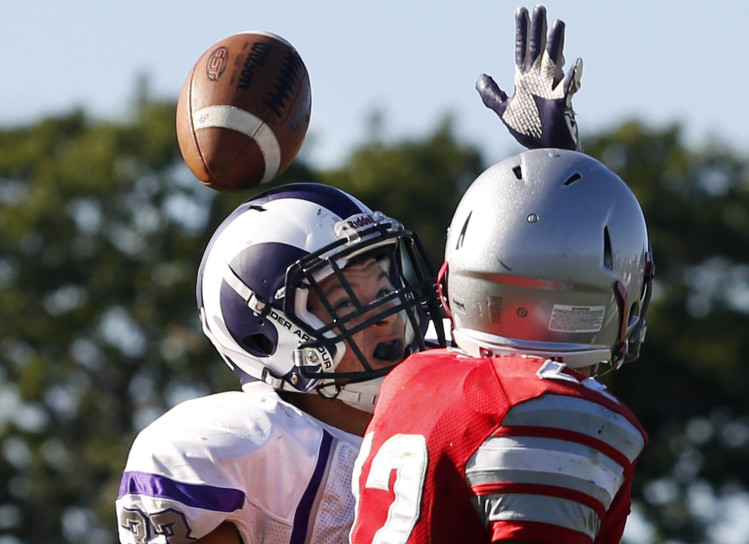 Rob Dacey, left, of Deering breaks up a pass intended for Spencer Houlette of South Portland on the final play of the first half Saturday. The ball bounced off his helmet and was intercepted by teammate Pat Viola. Deering won, 27-14.