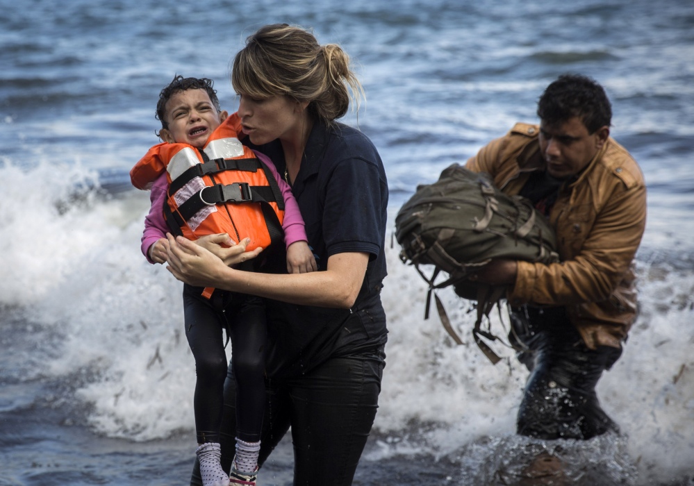 A volunteer holds a Syrian child after arriving with a group of migrants on a dinghy from the Turkish coast to the Greek island of Lesbos on Wednesday.