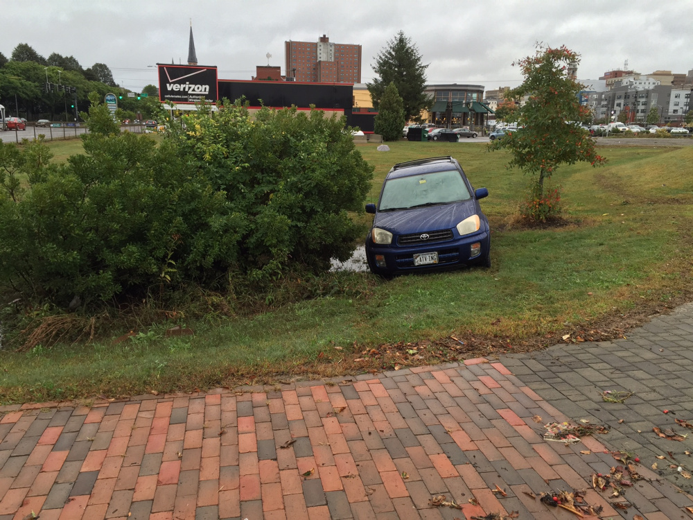 Ollie LaChapelle’s car sits near the Bayside Trail between the Verizon store and Planet Dog after floodwaters subsided Wednesday afternoon. Earlier, she waded through thigh-deep water after the car was inundated.
Dennis Hoey/Staff Writer