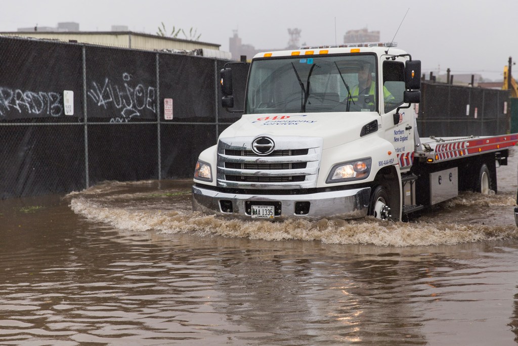 A tow truck creates a wake as it pushes through the water on Kennebec Street on its way to assist stranded motorists in the Bayside neighborhood after a soaking rain in Portland on Sept. 30, 2015.
